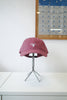 A dusty rose pink baseball cap with a white embroidered logo reading 'Bloom' and a small flower icon, displayed on a silver metal stand on a white table.