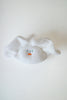 A white textured fabric hair claw clip shaped like a small bunny face, featuring embroidered blue eyes and a tiny orange nose, shown on a plain white background.