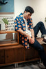 model side mid-shot of a Hong Kong made GOC Studio navy and orange daffodil cotton poplin shirt