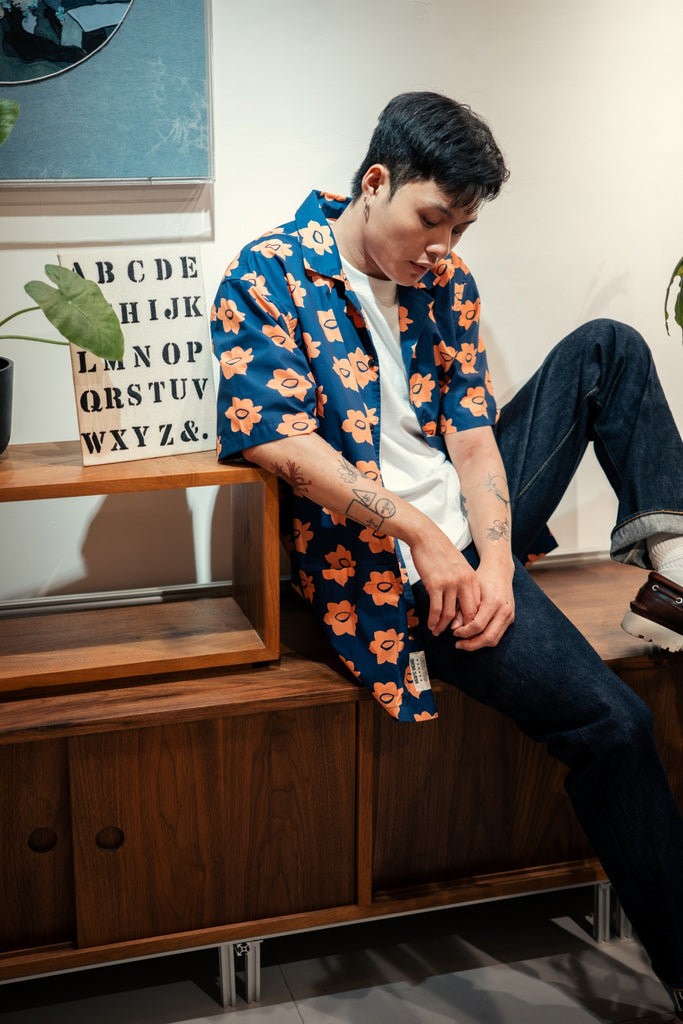 model side mid-shot of a Hong Kong made GOC Studio navy and orange daffodil cotton poplin shirt