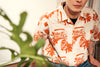 model close up shot of a Hong Kong made GOC Studio orange teapot Tencel linen shirt
