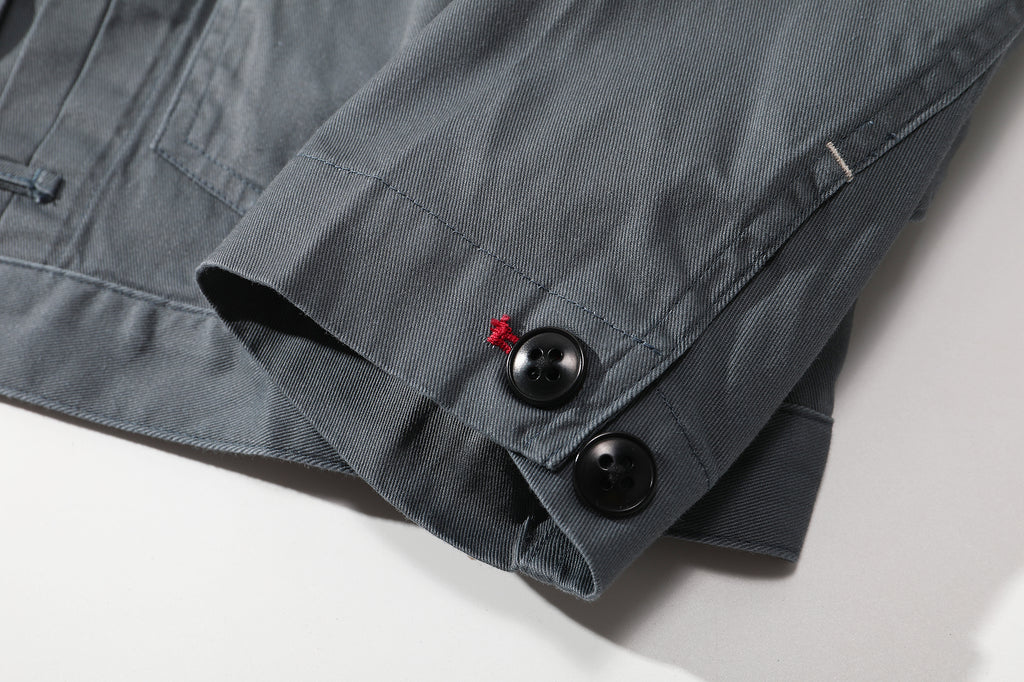 close up of sleeve hem and corozo button closure on a Hong Kong made GOC Studio steel blue Japanese cotton twill oriental jacket
