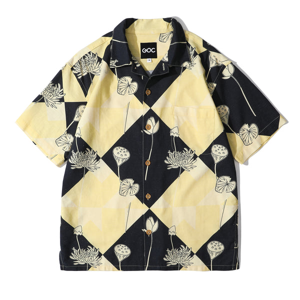 A short-sleeved patterned shirt with a geometric and floral design, predominantly in black and yellow, with a collar and chest pocket.