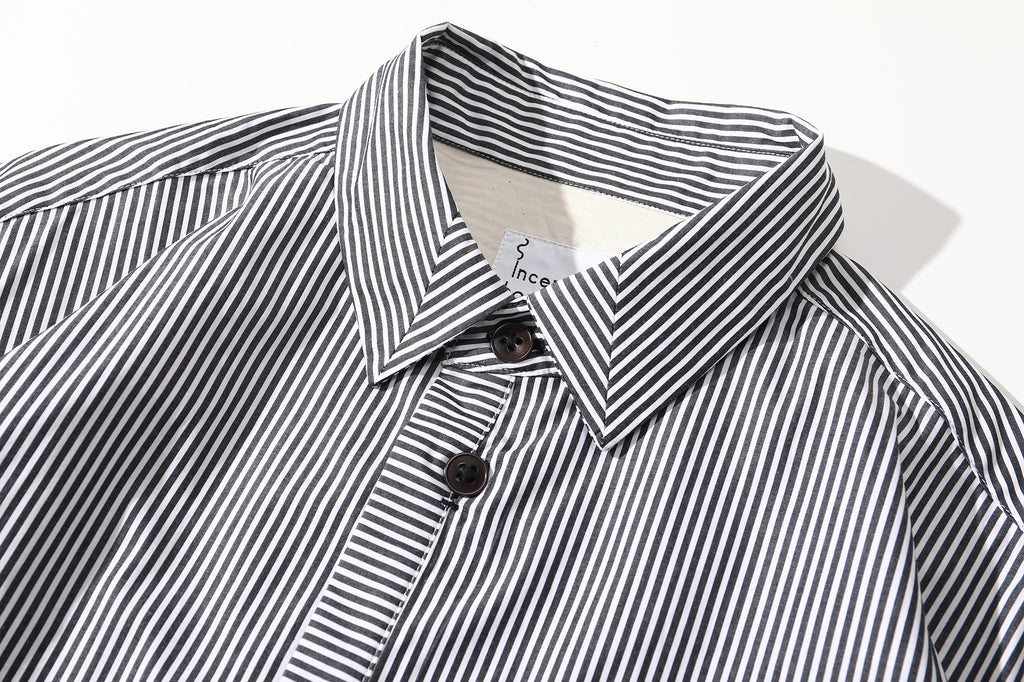 close up of mitered stripe contrast detail on collar of black summer shirt