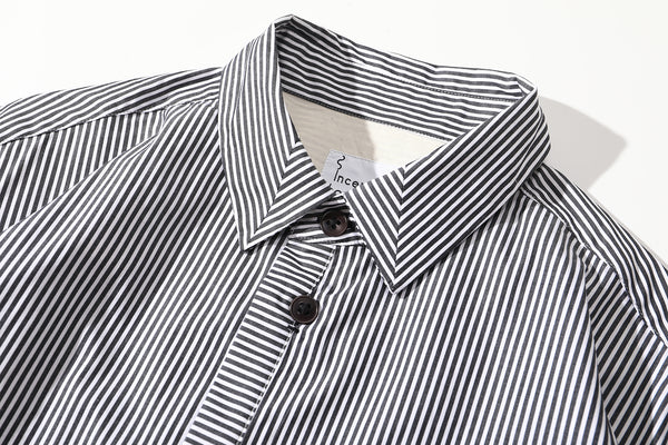close up of mitered stripe contrast detail on collar of black summer shirt