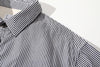 close up of mitered stripe contrast placket and corozo button closure on cotton shirt