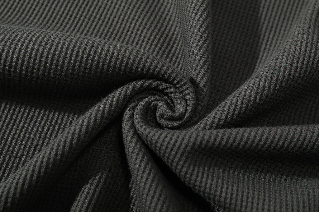 close up of ih charcoal jumper textured cotton waffle knit fabric