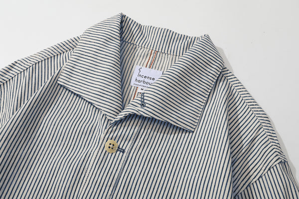 close up of unique swallow collar and neckline design on navy stripe jacket