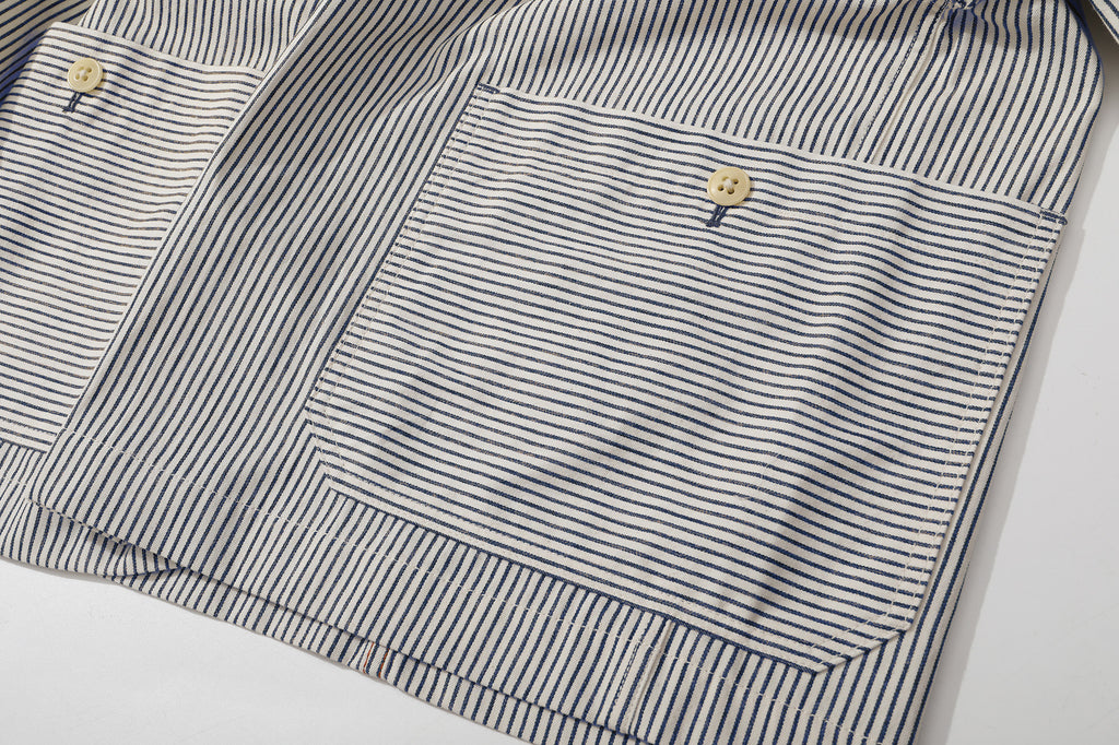 close up of unique cross side seams patch pockets detail on navy stripe jacket