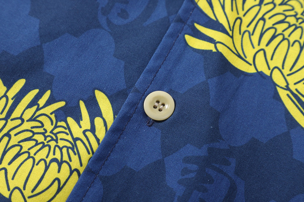 close up of corozo button closure on a Hong Kong made GOC Studio blue and yellow chrysanthemum cotton shirt
