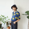 female model side mid-shot of a Hong Kong made GOC Studio blue and yellow chrysanthemum cotton shirt