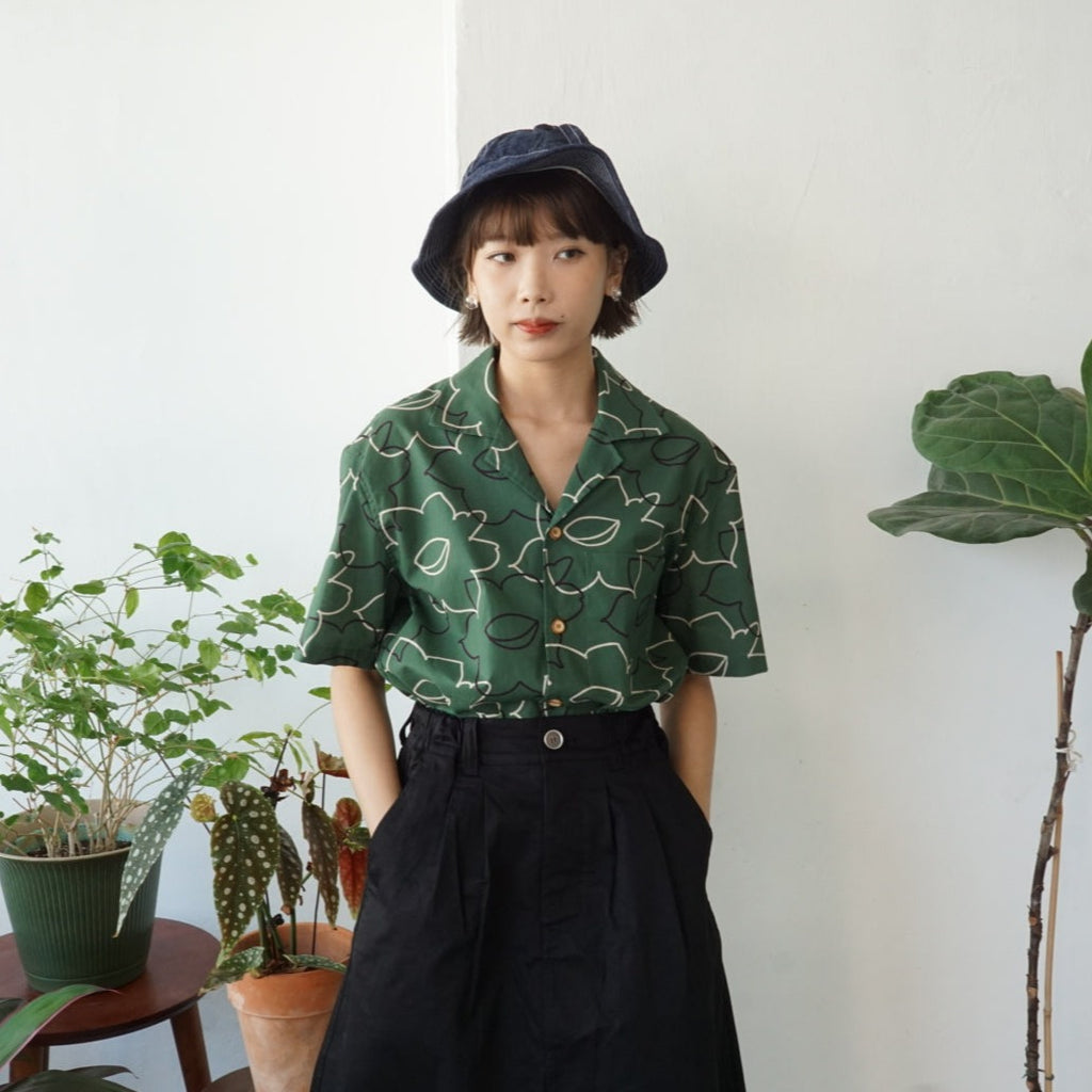 female model mid-shot of a Hong Kong made GOC Studio green daffodil Tencel linen shirt