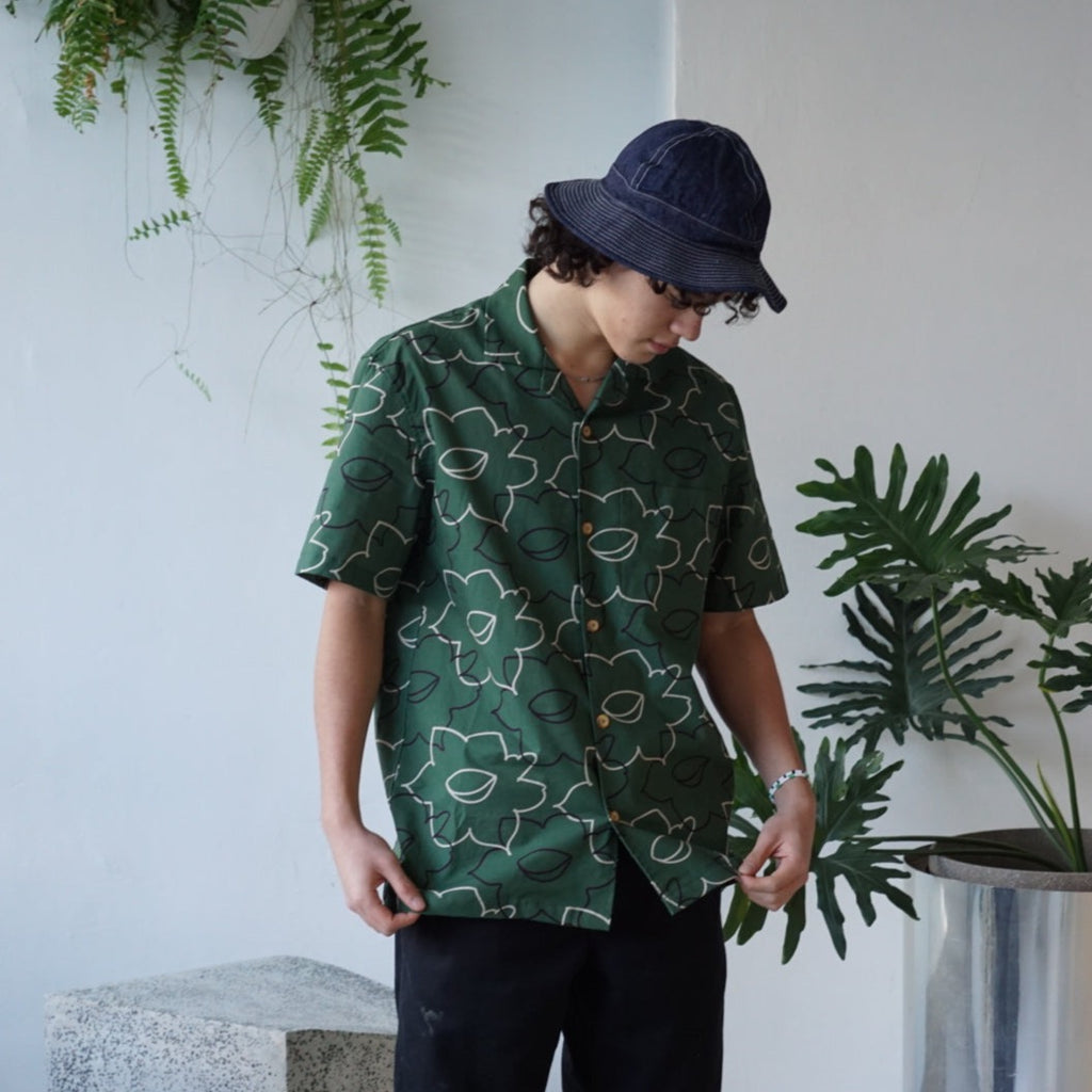 male model mid-shot of a Hong Kong made GOC Studio green daffodil Tencel linen shirt