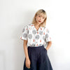 female model mid-shot of a Hong Kong made GOC Studio white and red badminton cotton poplin shirt