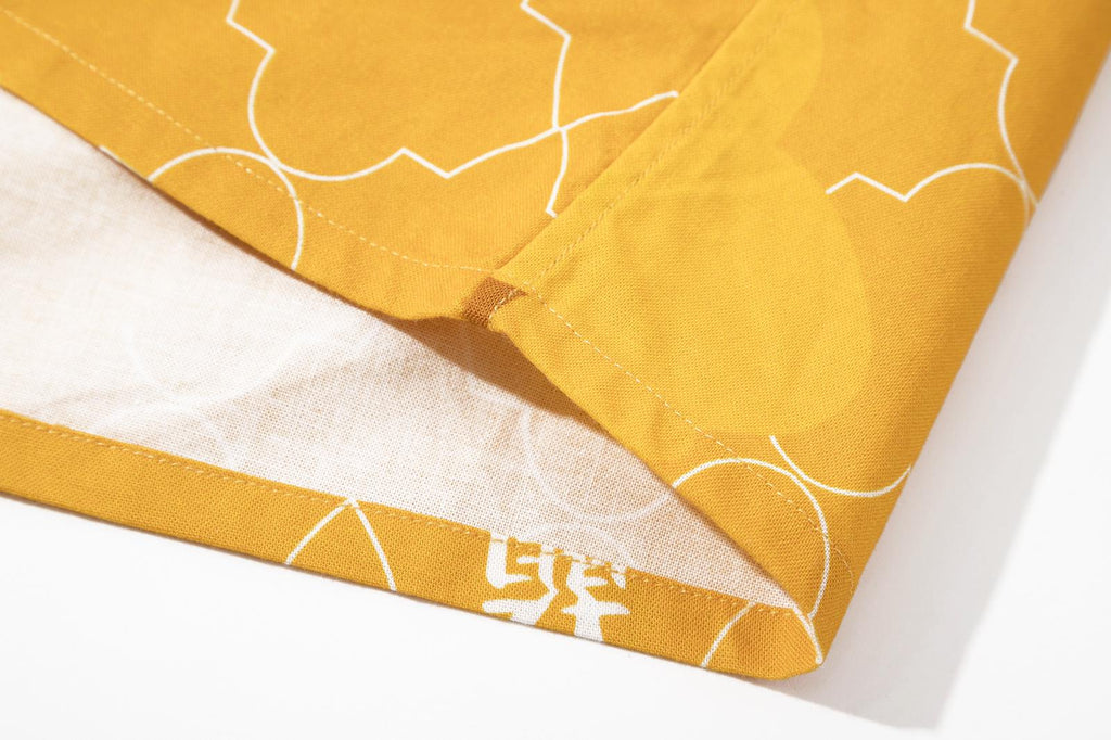 bottom hem view of a Hong Kong made GOC Studio yellow orchid cotton shirt